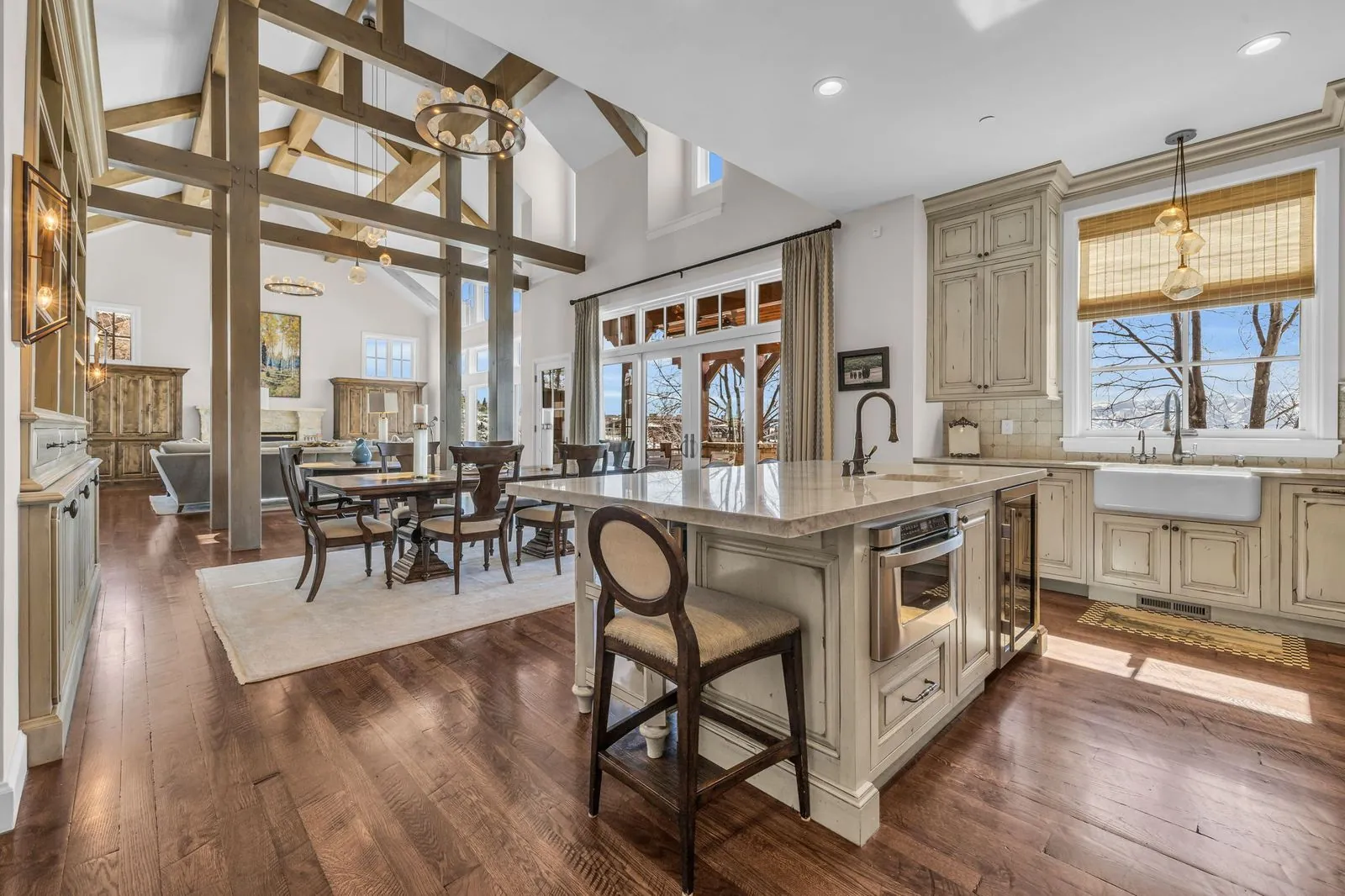Kitchen with a stone island, cream cabinetry and timber posts